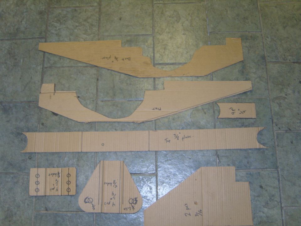 cardboard cutouts laid out on a tiled floor, some with handwritten notes