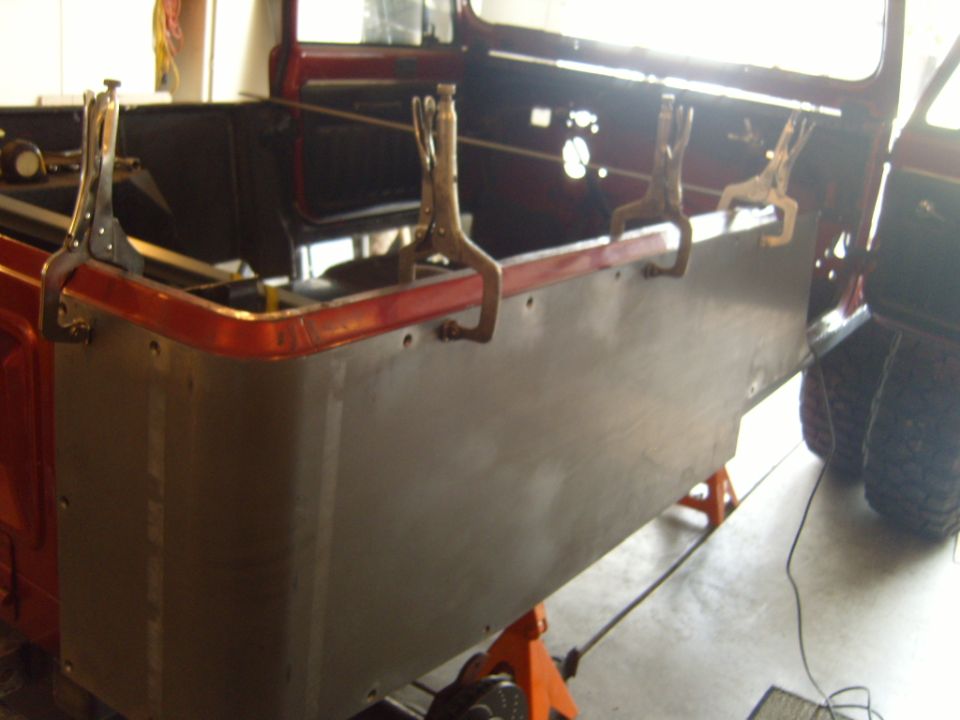 Jeep CJ body being worked on, clamps holding new panel in place