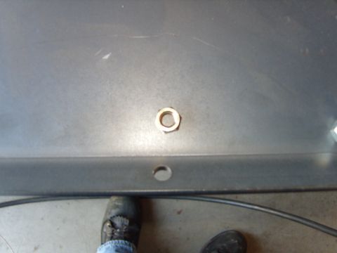 1985 Jeep CJ7 - A close-up view shows a single nut secured to a gray metal panel, with a hole visible beneath it.