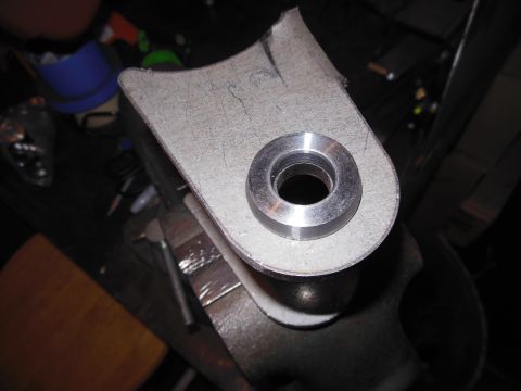 1985 Jeep CJ7 - A metal bracket with a bushing is clamped in a vise, ready for modification or installation.