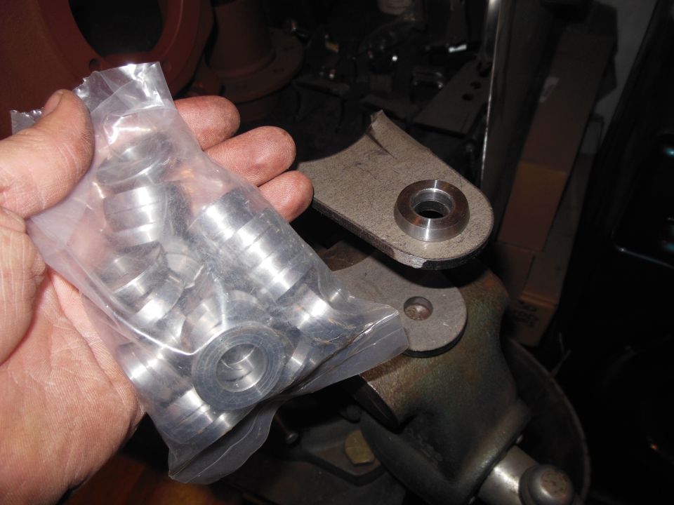 Bag of metal washers held in hand, next to a metal bracket with a circular hole