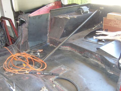 1985 Jeep CJ7 - The interior of a vehicle is shown with welding equipment and metal panels, indicating ongoing repair or modification work.
