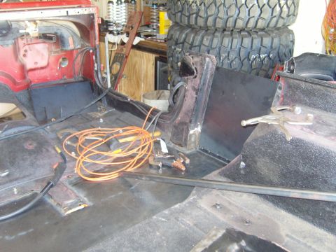 1985 Jeep CJ7 - Interior view of a Jeep undergoing modifications, with welding equipment and spare tires visible.
