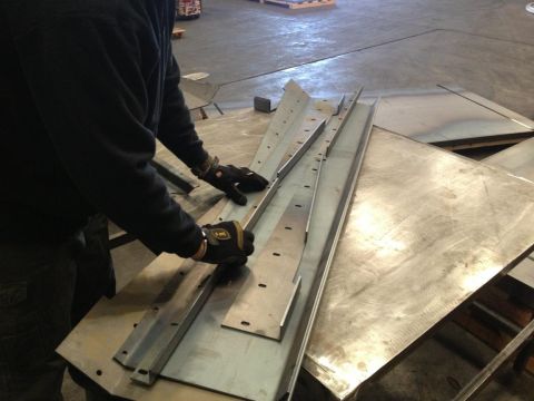 1985 Jeep CJ7 - Metal components are laid out on a workshop floor, ready for assembly or fabrication.