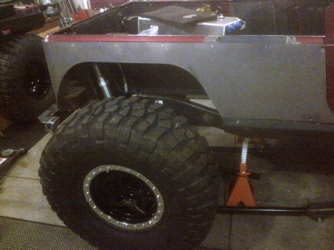 1985 Jeep CJ7 - The rear section of a Jeep CJ is shown, elevated on jack stands with oversized tires.