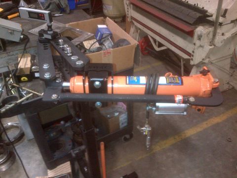 1985 Jeep CJ7 - Hydraulic tube bender setup in a workshop environment, a digital readout and orange hydraulic cylinder.