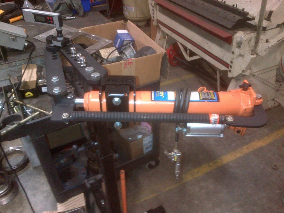 Tube bender with orange hydraulic ram and digital readout