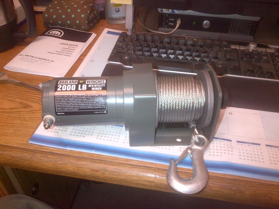 Badland 2000 LB ATV/Utility Winch with hook and cable on a desk