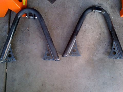 1985 Jeep CJ7 - Two fabricated Jeep roll cage sections are laid out on a concrete floor, ready for installation.