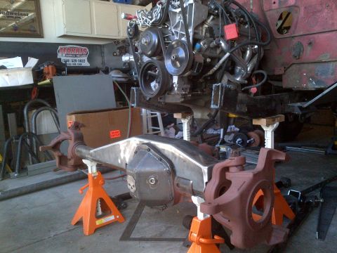 1985 Jeep CJ7 - Engine and front axle assembly are supported by jack stands in a workshop setting.