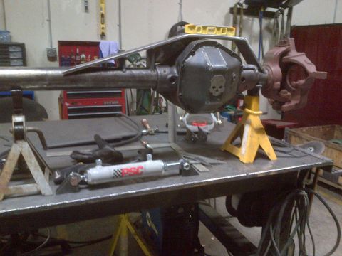 1985 Jeep CJ7 - A custom differential housing with a skull emblem is shown on jack stands in a workshop setting.