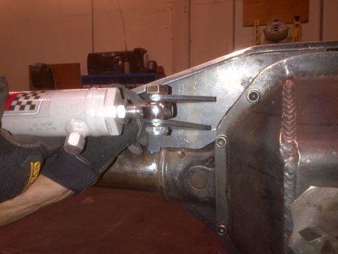 1985 Jeep CJ7 - A shock absorber is being bolted to a custom bracket on a vehicle's differential housing.