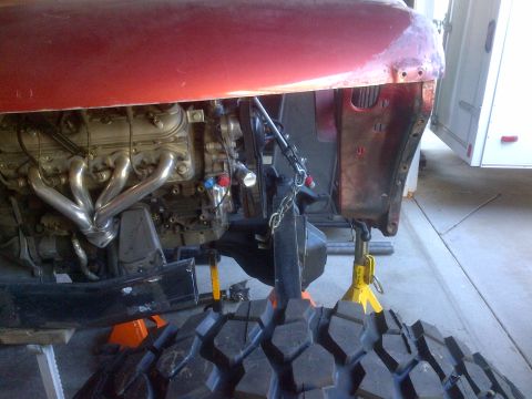 1985 Jeep CJ7 - Vehicle undergoing engine and chassis work with parts laid out.