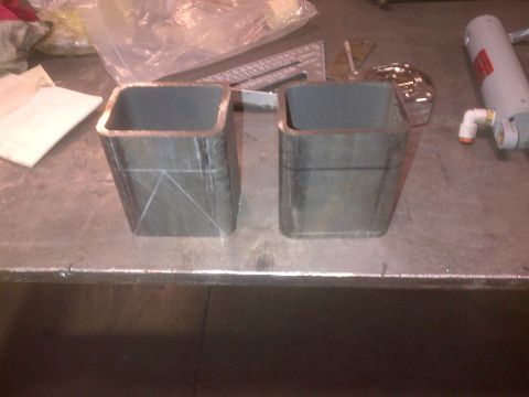 1985 Jeep CJ7 - Two metal tubes, possibly for fabrication, are shown on a workbench with scribe lines indicating measurements.