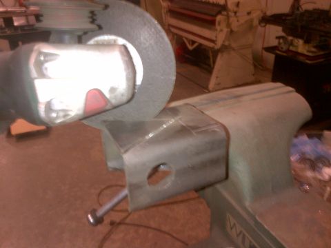 1985 Jeep CJ7 - Metal part being ground in a vise with an angle grinder.