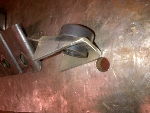 1985 Jeep CJ7 - A close-up view of a metal bracket and bushing, likely a vehicle component.