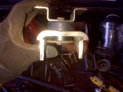 1985 Jeep CJ7 - Close-up of a vehicle engine mount part being held by a gloved hand.