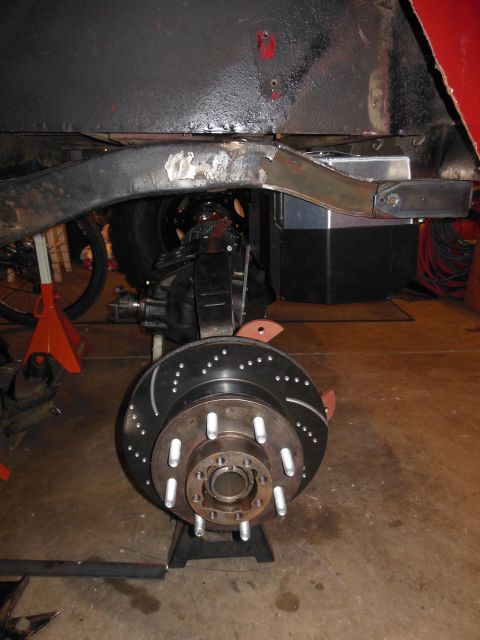 1985 Jeep CJ7 - Close-up of a Jeep CJ's frame and suspension components, including a large brake rotor and caliper.