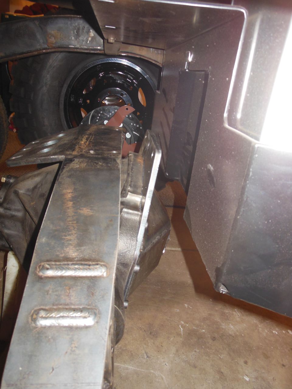 Jeep CJ7 rear axle with custom metal fabrication and a large tire