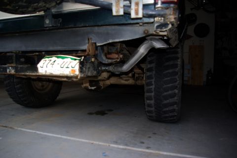 1995 Ford Bronco - The rear underside of a vehicle is shown, including the axle, tires, and exhaust system, with a license plate visible.