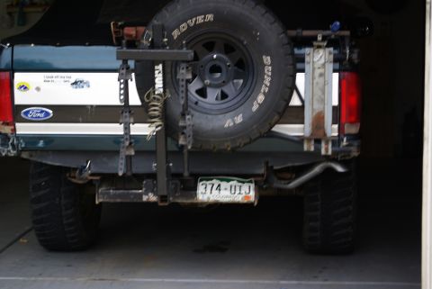 1995 Ford Bronco - The rear of a Ford Bronco is shown, a spare tire, a license plate, and various stickers on the tailgate.