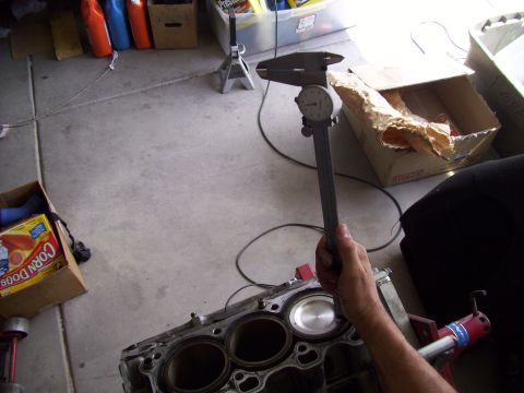 1995 Ford Probe - Measuring engine block cylinders with a caliper in a garage setting.