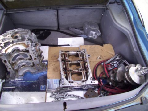1995 Ford Probe - Various engine components are stored in the trunk of a vehicle.