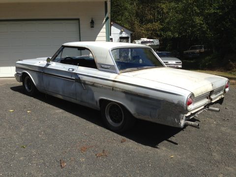 1964 Ford Fairlane - This vintage Ford Falcon is parked in front of a garage, showing signs of bodywork and custom exhaust.