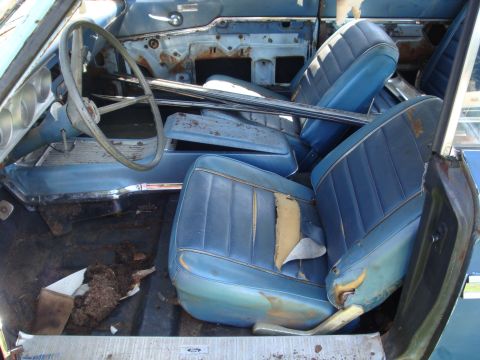 1964 Ford Fairlane - The interior of a 1964 Ford Fairlane shows blue vinyl seats and dashboard, with visible wear and tear.