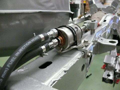 1976 Chevrolet Corvette - Close-up of a fuel filter and hoses mounted on a bare metal vehicle chassis.