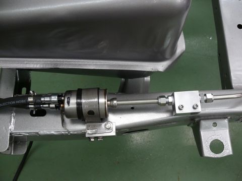 1976 Chevrolet Corvette - Close-up view of a fuel injection hose and filter assembly mounted to a vehicle's chassis.