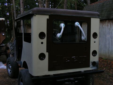 Cream and black van, rear view, with dark tinted windows and round taillights