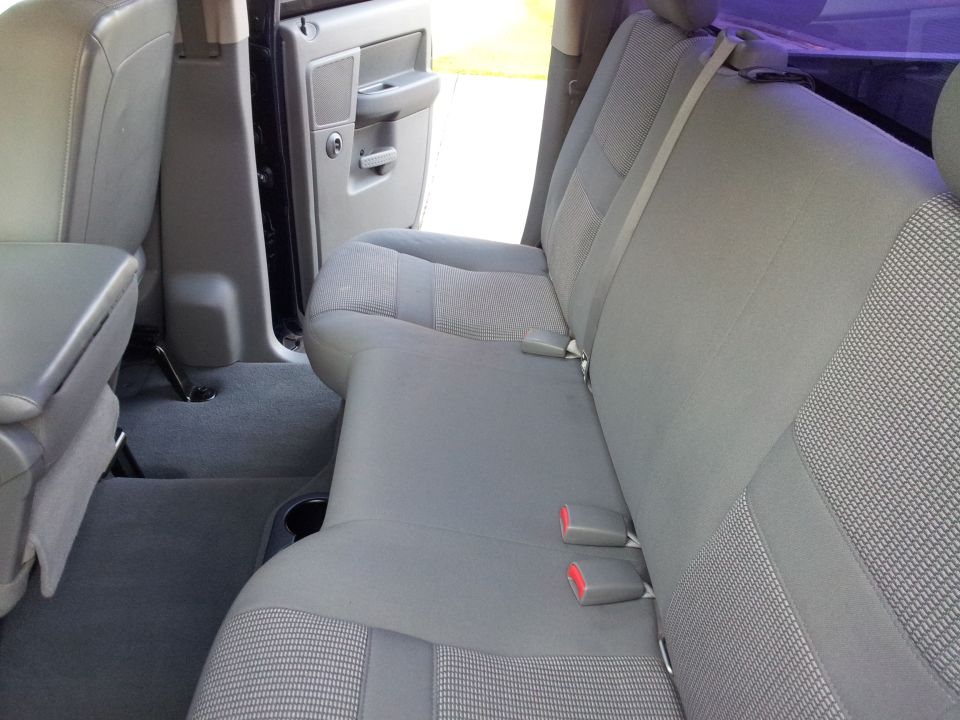 Gray fabric rear bench seat and floor of a truck interior.