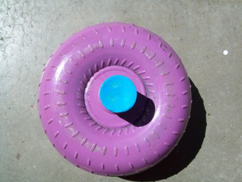 1993 Ford F-150 - A purple torque converter with a blue cap sits on a concrete surface, casting a shadow.