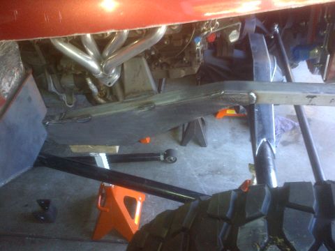 1985 Jeep CJ7 - Underbody view of a vehicle undergoing modifications, showing engine, exhaust, and frame work.