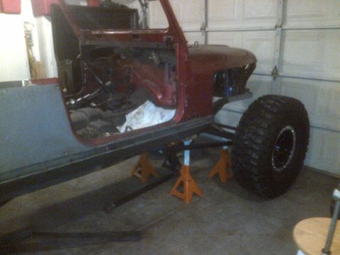 1985 Jeep CJ7 - This 1985 Jeep CJ7 is undergoing modifications, supported by jack stands in a garage.