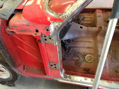 1964 Ford Fairlane - Interior view of a red car undergoing repairs, showing exposed metal and disassembled components.