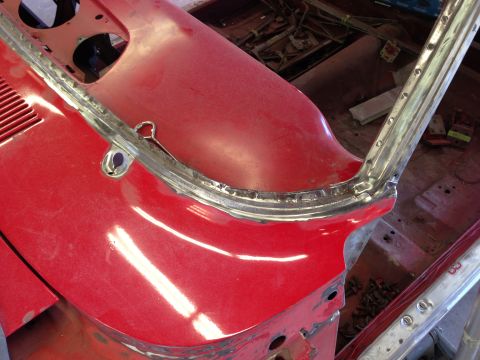 1964 Ford Fairlane - Close-up of the red windshield frame and cowl area of a 1964 Ford Fairlane undergoing restoration.
