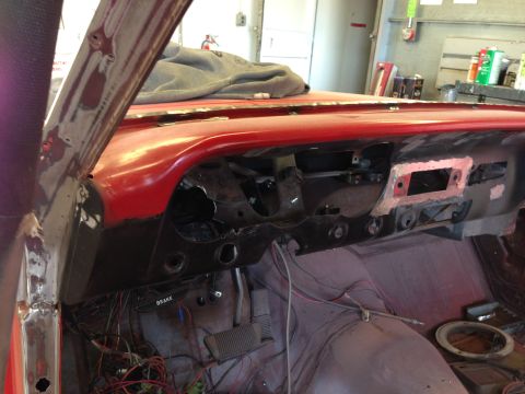 1964 Ford Fairlane - The dashboard of a car is disassembled, revealing exposed wiring and the brake pedal assembly.