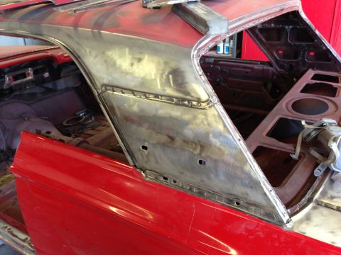 1964 Ford Fairlane - Metalwork on a red car's rear pillar and roofline indicates body repair is in progress.