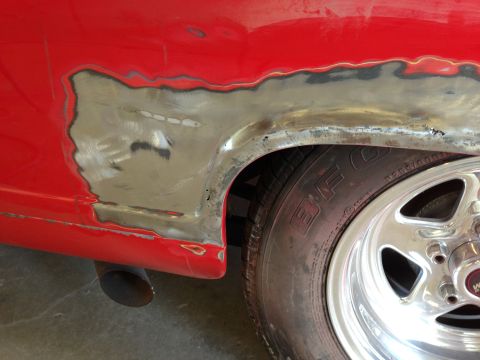 1964 Ford Fairlane - Bodywork in progress on a red vehicle's rear fender, near the wheel well.
