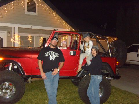 1985 Jeep CJ7 - A family poses with a red 1985 Jeep CJ7 during the holidays.