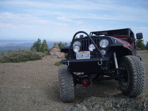 1985 Jeep CJ7 - This 1985 Jeep CJ7 is equipped for off-road adventures, parked on a scenic mountain trail.