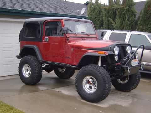 1985 Jeep CJ7 - This red Jeep CJ is equipped with off-road tires and a winch on the front bumper.