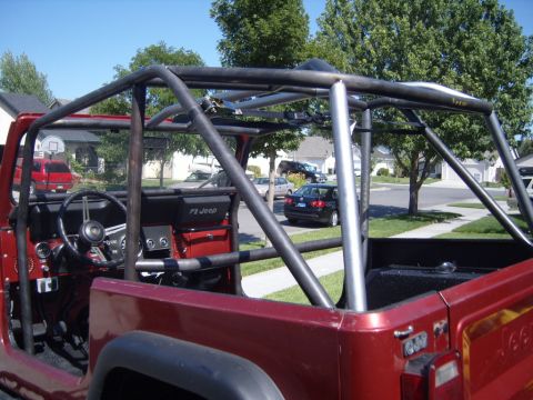 1985 Jeep CJ7 - Interior view of a 1985 Jeep CJ7 with a prominent aftermarket roll cage installed.
