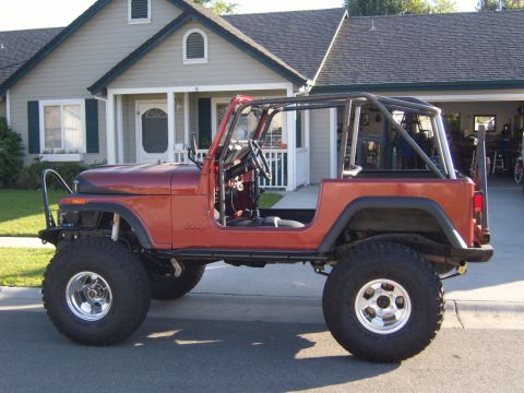 1985 Jeep CJ7 - This 1985 Jeep CJ7 is shown from the side, a roll cage and off-road tires.