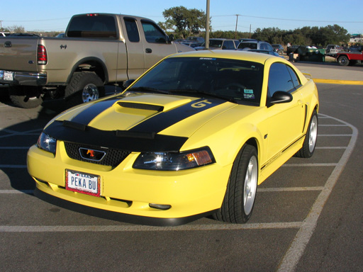 Yellow 2003 Ford Mustang GT, 3q-front view, with black racing stripes and a GT badge
