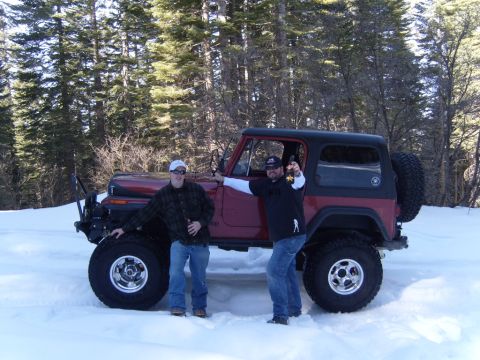 1985 Jeep CJ7 - Two men stand next to a red Jeep CJ in a snowy, wooded area.