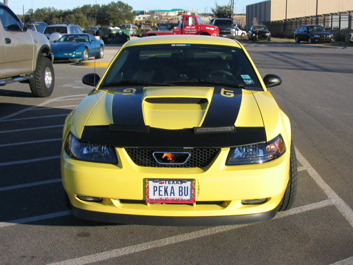 Yellow 2003 Ford Mustang with black racing stripes on the hood and trunk