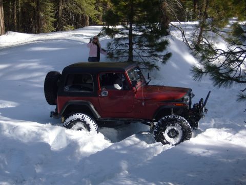 1985 Jeep CJ7 - This 1985 Jeep CJ7 is navigating a snowy trail, with a person observing from the side.